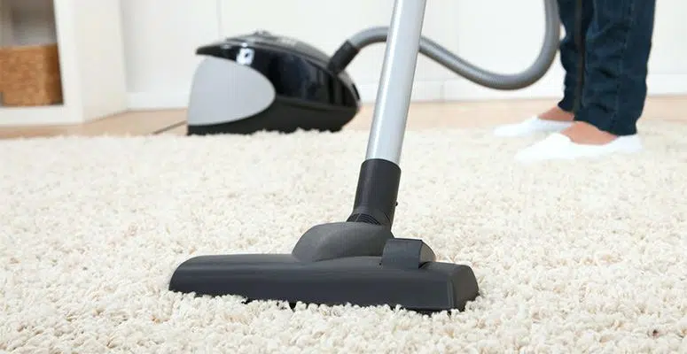 Vacuuming carpet thoroughly before cleaning it by hand