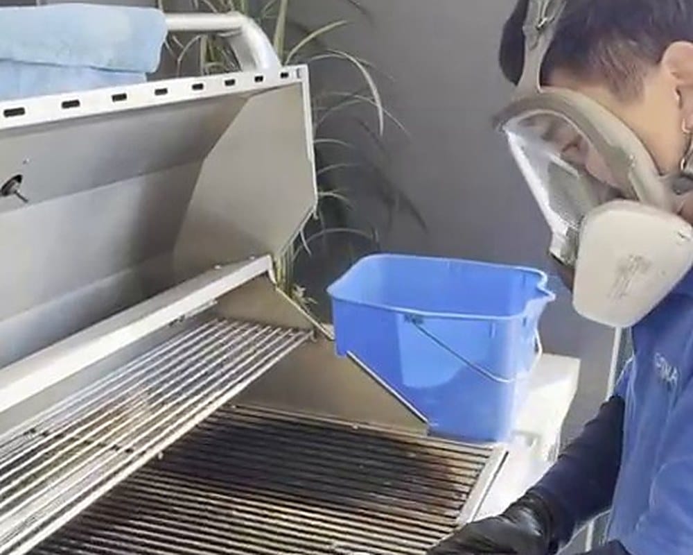Optima Cleaners technician wearing a respirator while cleaning a BBQ in Brisbane