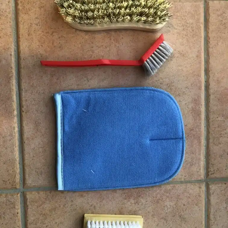 Soft brushes and a microfibre cloth used to work a stain out of carpet