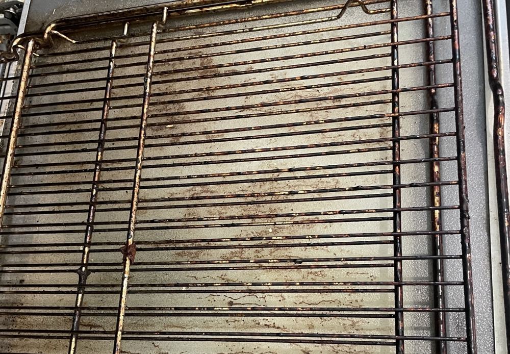 Oven racks coated in burnt-on grease before cleaning